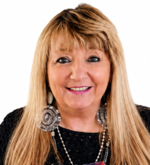 Woman with long blonde hair and bangs wearing black top and silver circular earrings